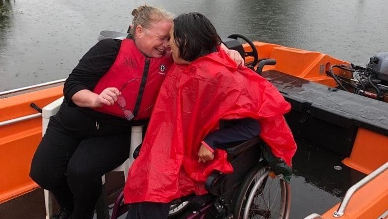 Caregiver and client sharing a heartfelt moment on a boat, highlighting compassionate and personalised care.